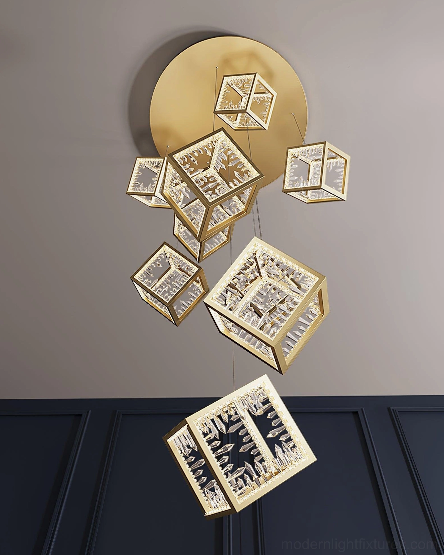 Gold cubic chandelier installed in spiral stairwell creating dramatic contemporary lighting effect