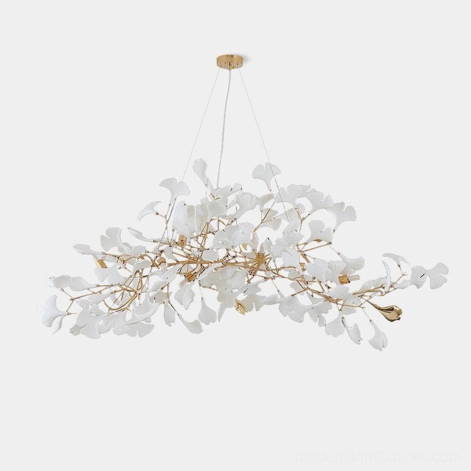 Gold ginkgo leaf linear chandelier front view with white ceramic leaves and adjustable metal branches on white background