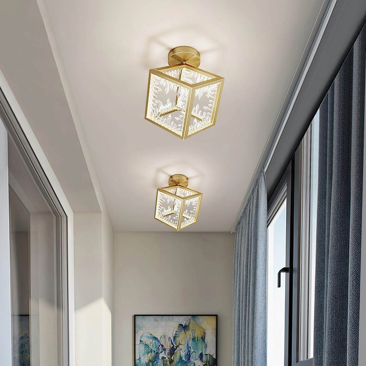 Matching pair of gold glass cube ceiling lights in residential hallway with wall art