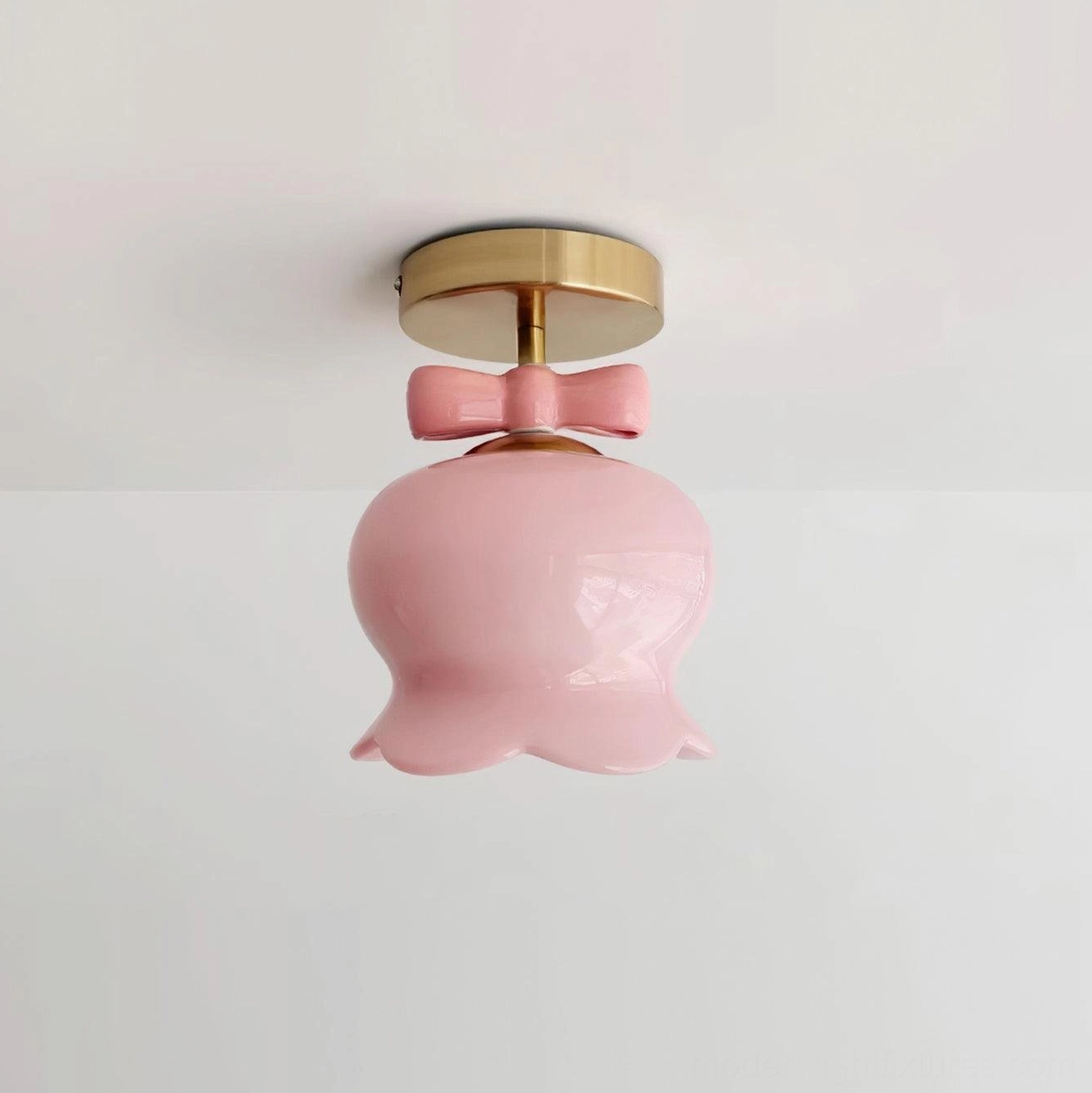 Gold finished bell ceiling light with pink glass shade pendant in styled interior setting demonstrating color coordination options