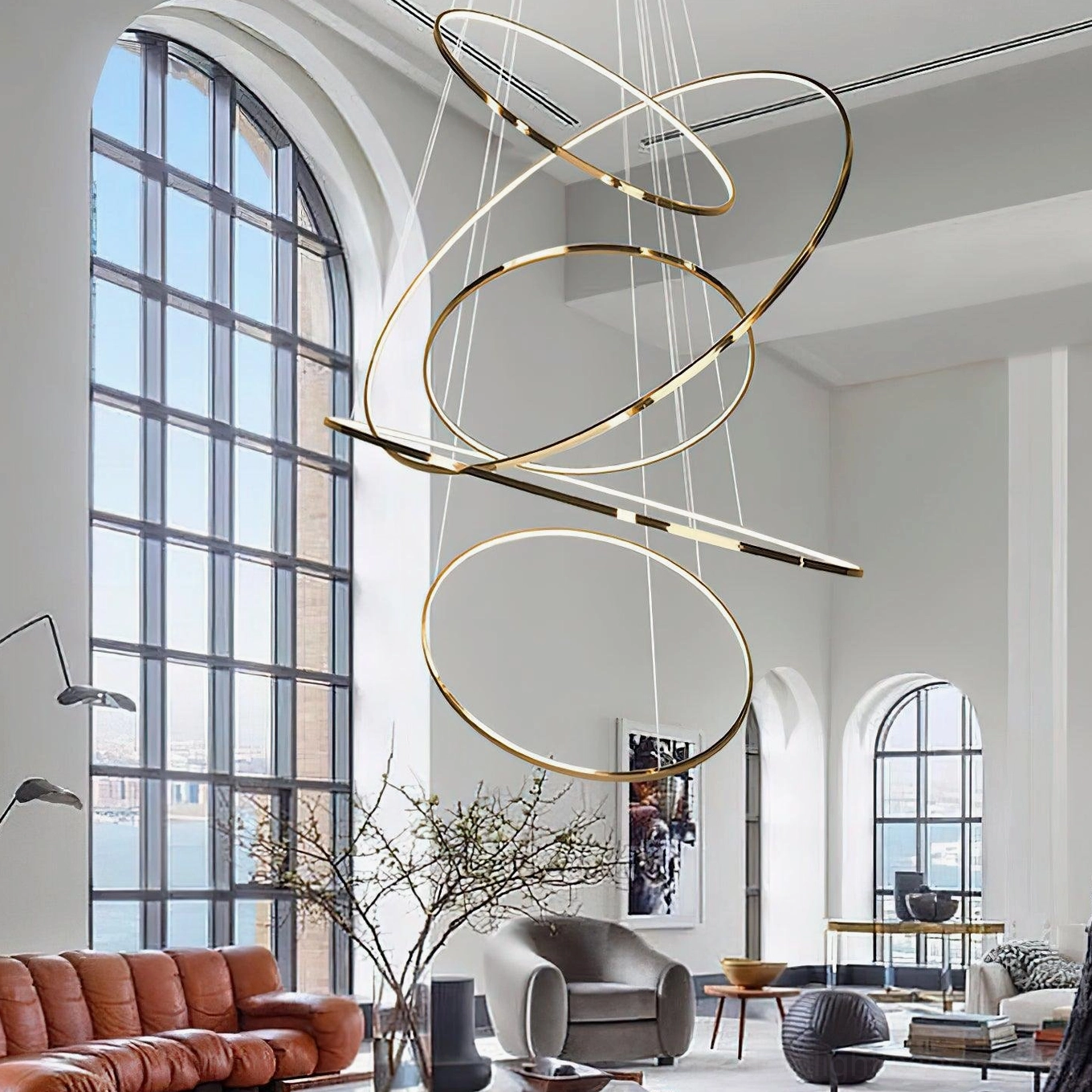 Luxury intertwined gold ring chandelier suspended from high ceiling in minimalist lounge with arched windows