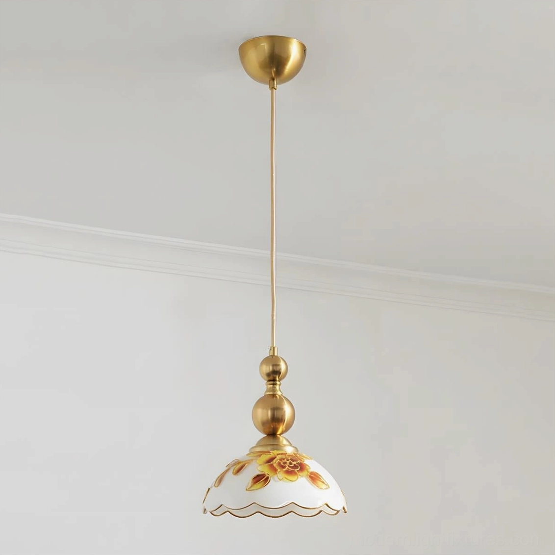 Gold finish single pendant light with yellow floral pattern and brass hardware detail