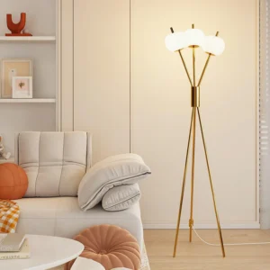 Gold polished tripod floor lamp with three frosted globe shades in contemporary beige living room setting
