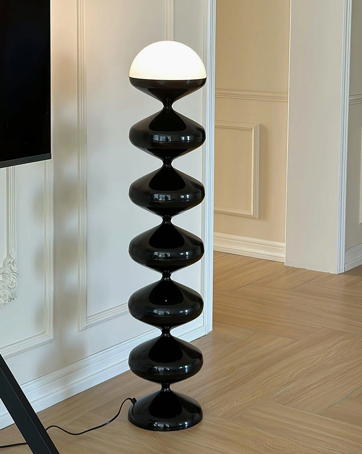 Contemporary sculptural gourd floor lamp in luxury minimalist living room with TV wall