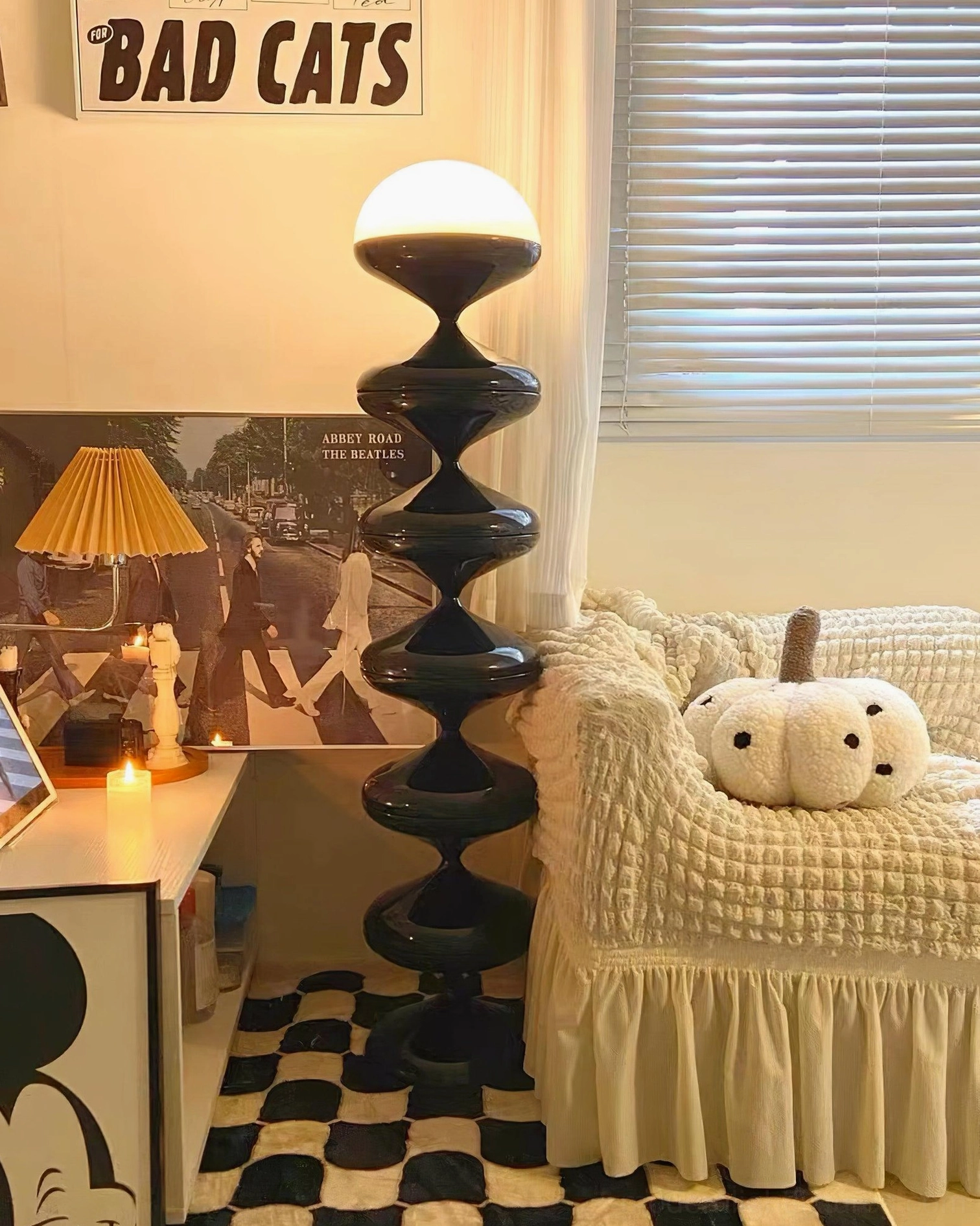 Modern sculptural gourd floor lamp illuminating reading nook chair in minimalist interior