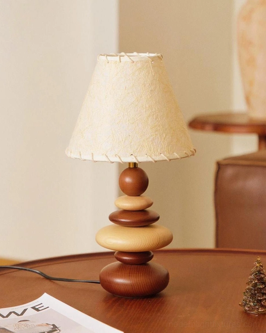Grainelle wood table lamp close-up showing whipstitched linen shade fabric detail and sculptural turned wood base on wooden table
