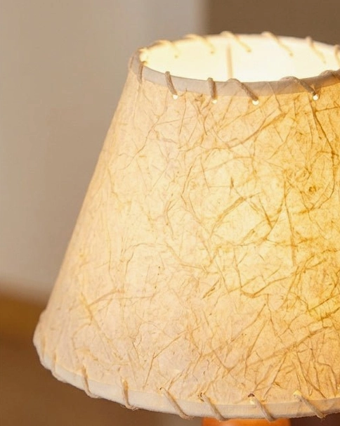 Grainelle table lamp showing warm 3000K LED light diffusing through linen fabric shade creating ambient bedroom glow