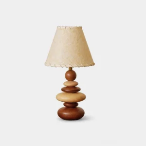 Grainelle stacked wood table lamp with walnut and beige tones, showing layered white-ash base and whipstitched linen shade on white background