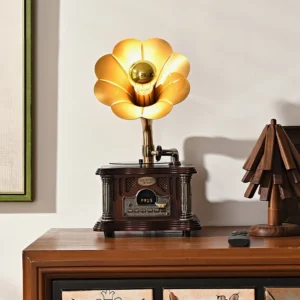 Retro gramophone-style table lamp with Bluetooth speaker on wooden cabinet with warm ambient lighting and framed wall art