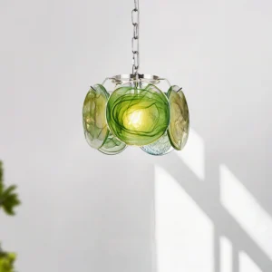 Green smoky art glass pendant lamp hanging in minimalist modern interior with natural sunlight