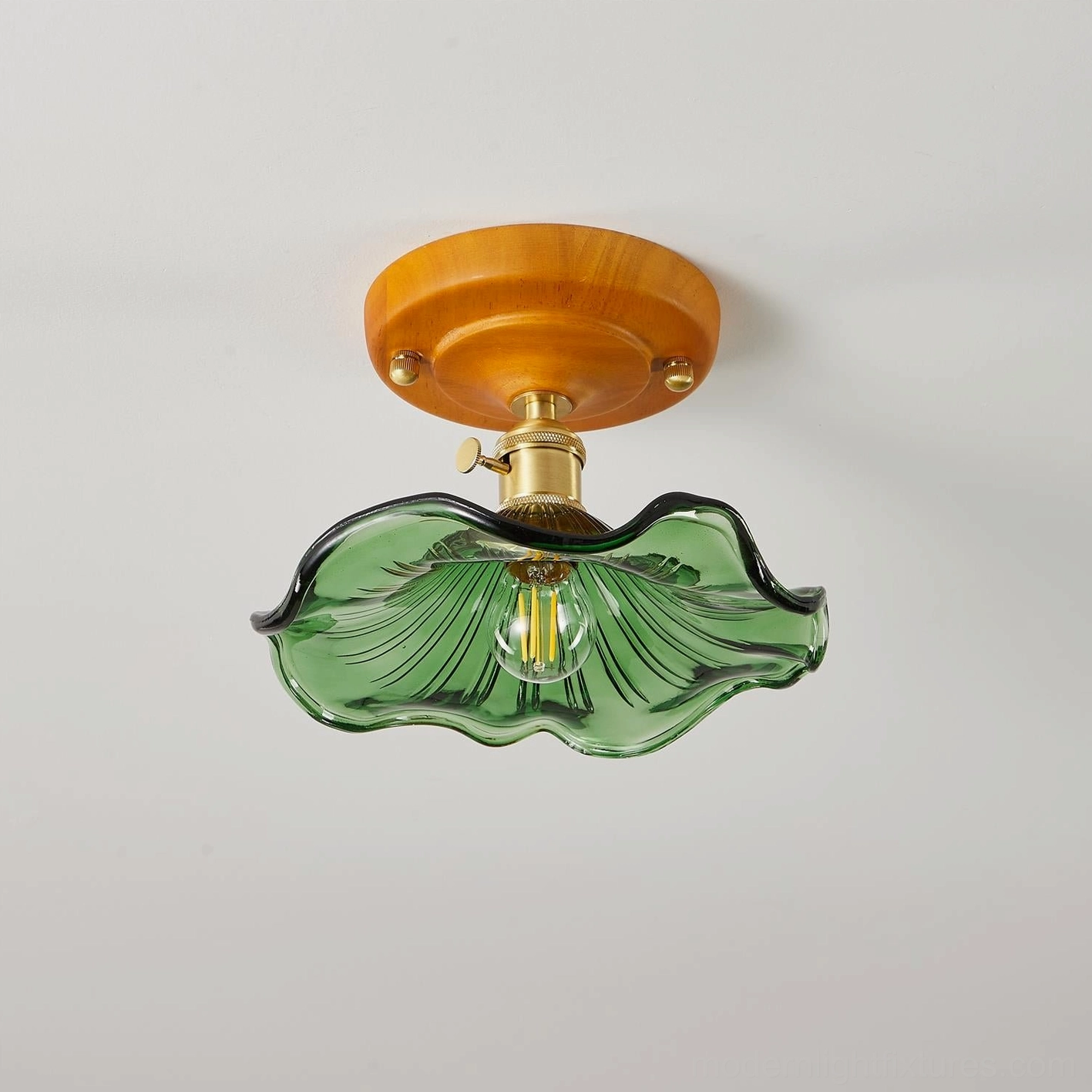 Bottom view of green rippled glass flush mount ceiling light showing brass lamp switch and fixture base