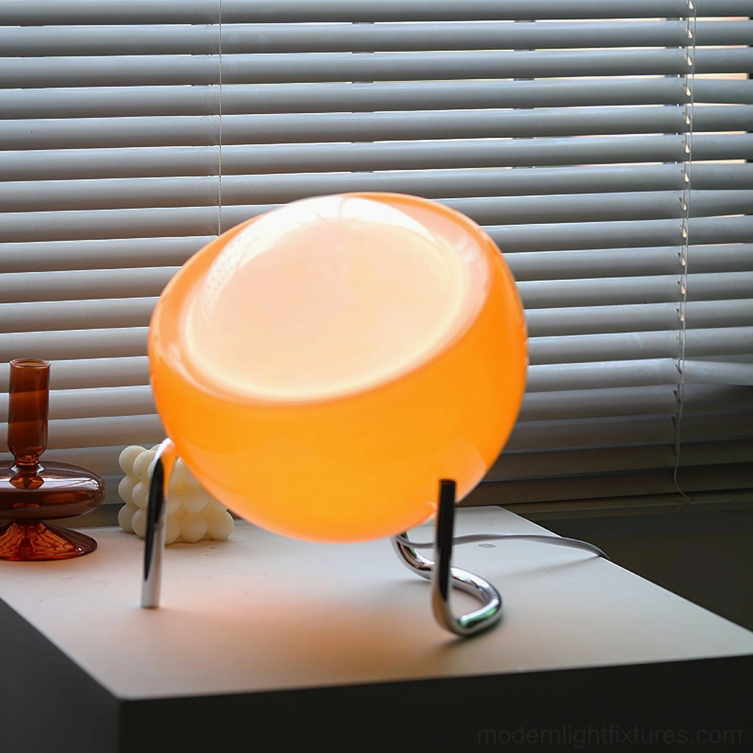 Green dome table lamp Bauhaus style with chrome curved stand on desk, contemporary interior styling