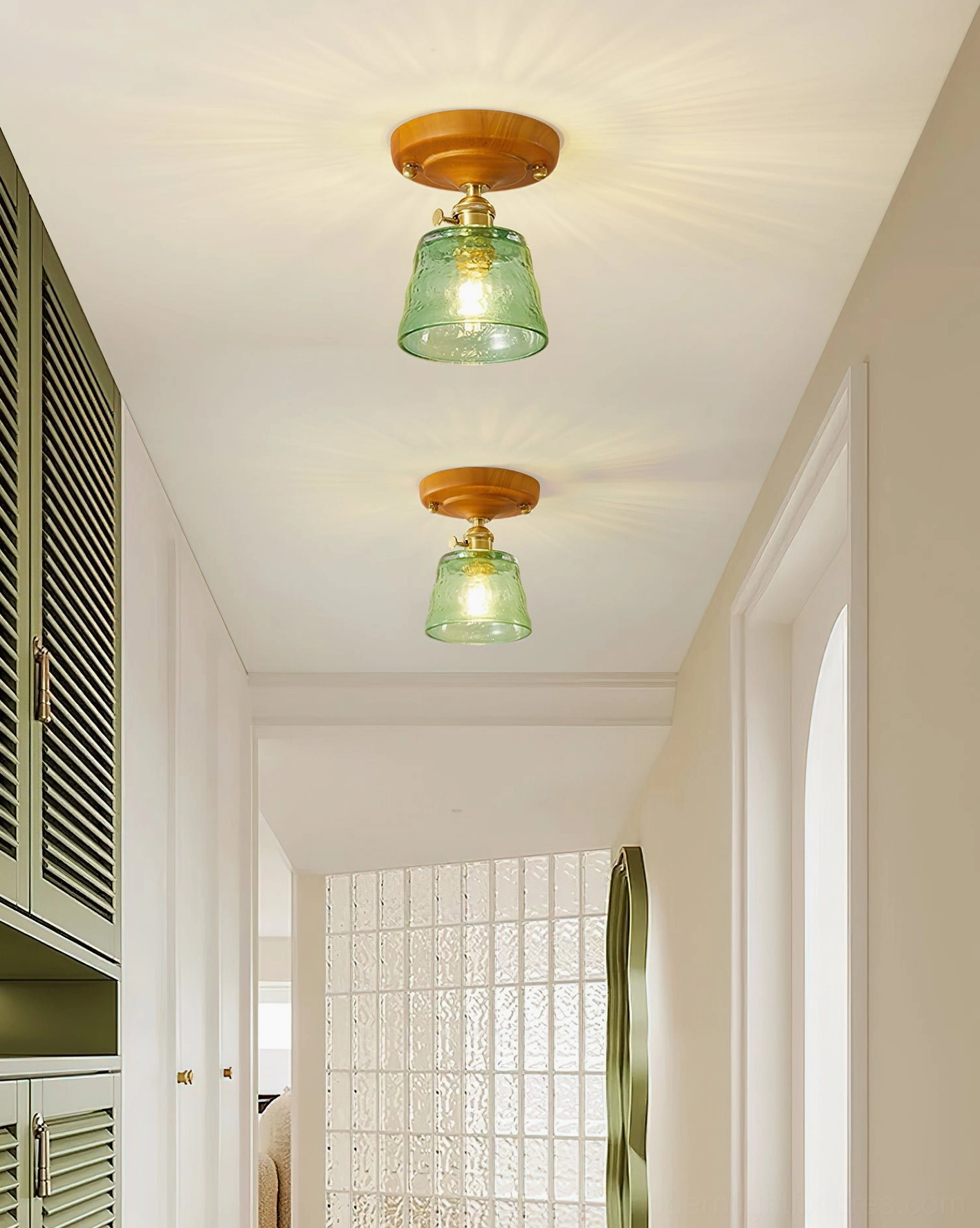 Dual vintage green glass ceiling light fixtures in residential hallway corridor with brass and wood hardware