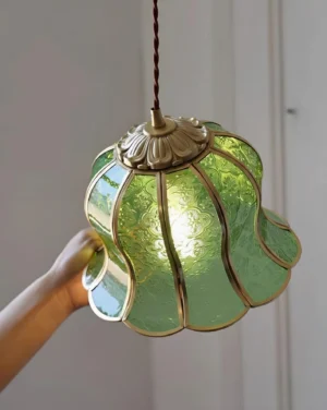 Green frosted glass bell pendant light with gold brass trim, side close-up detail view
