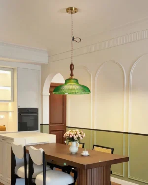 Retro green glass pendant light suspended above wooden dining table in French vintage dining room