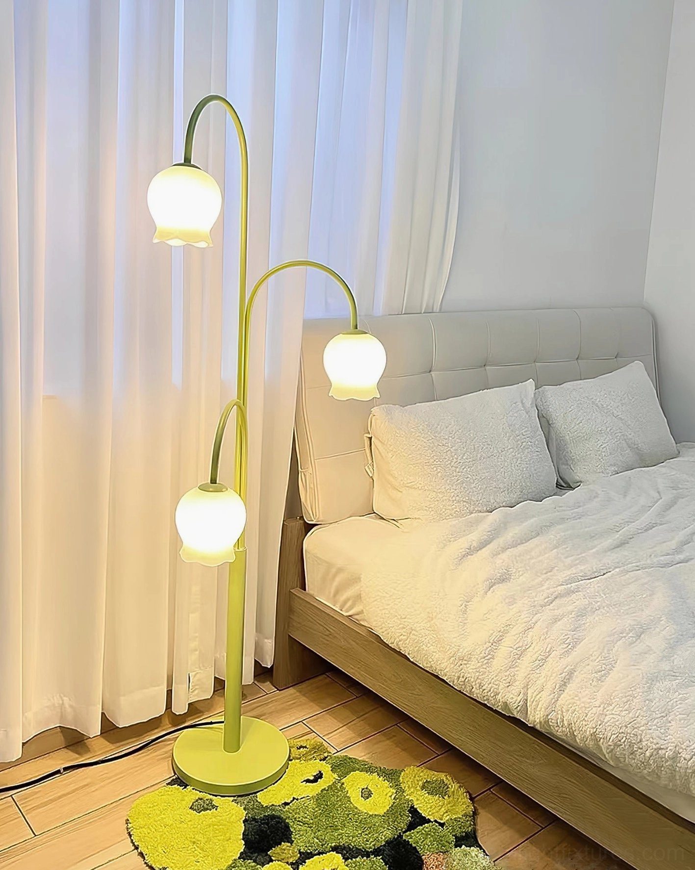 Green lily floor lamp eye-level view in bedroom with warm lighting and floral rug