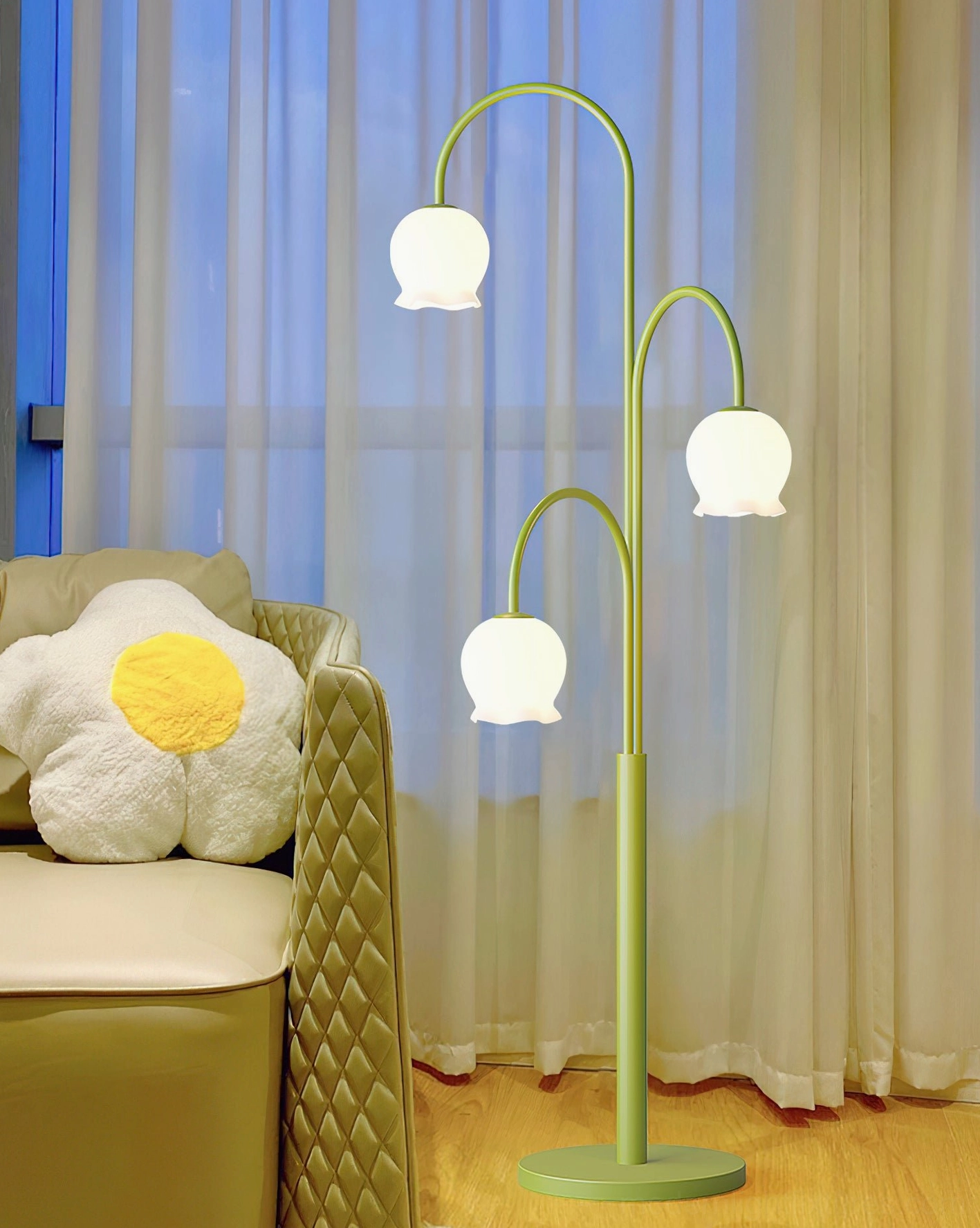 Cozy three-glowing-shades lily floor lamp in lounge space with soft green metal pole