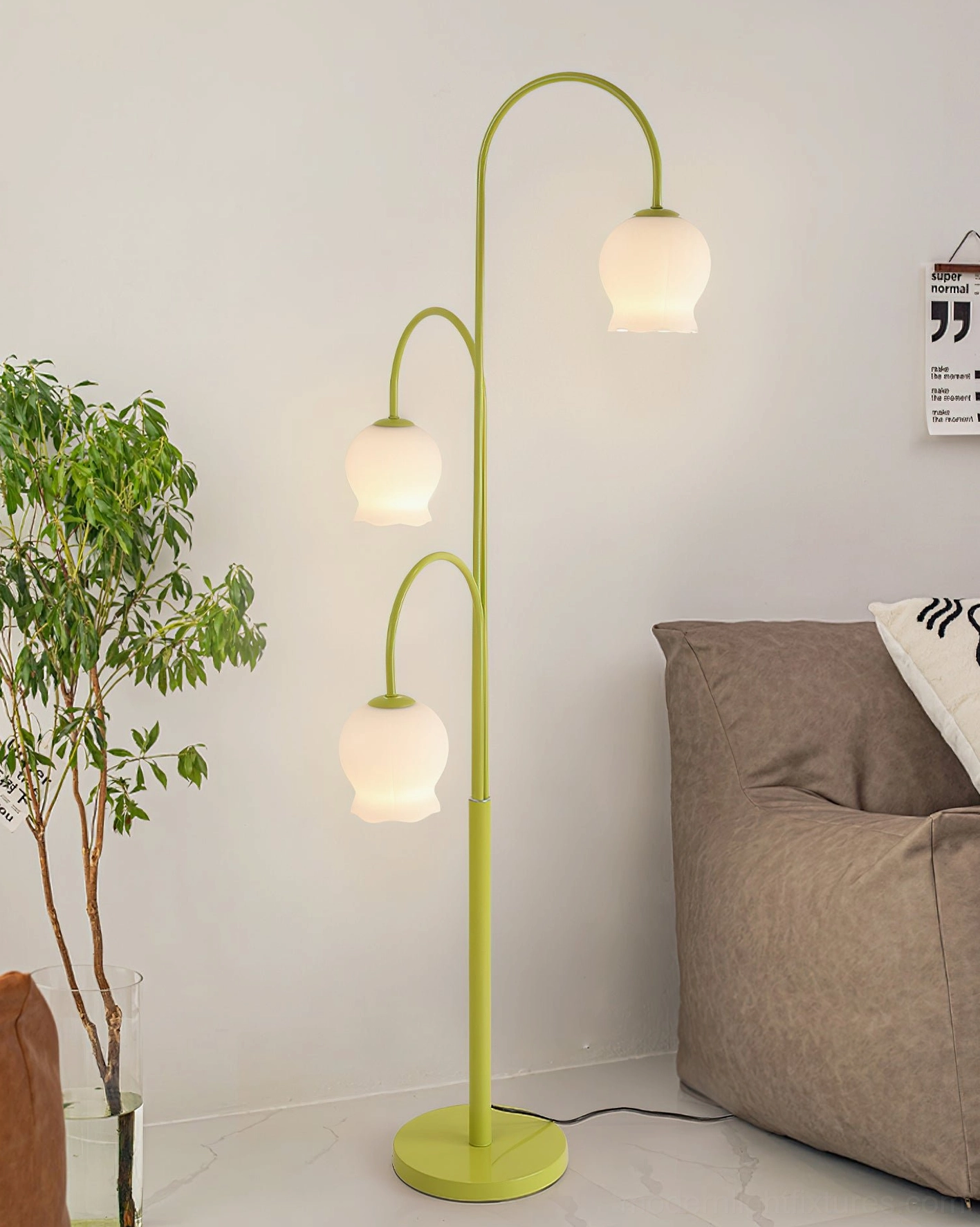 Green lily floor lamp three-quarter view in minimalist living room with sofa and plant