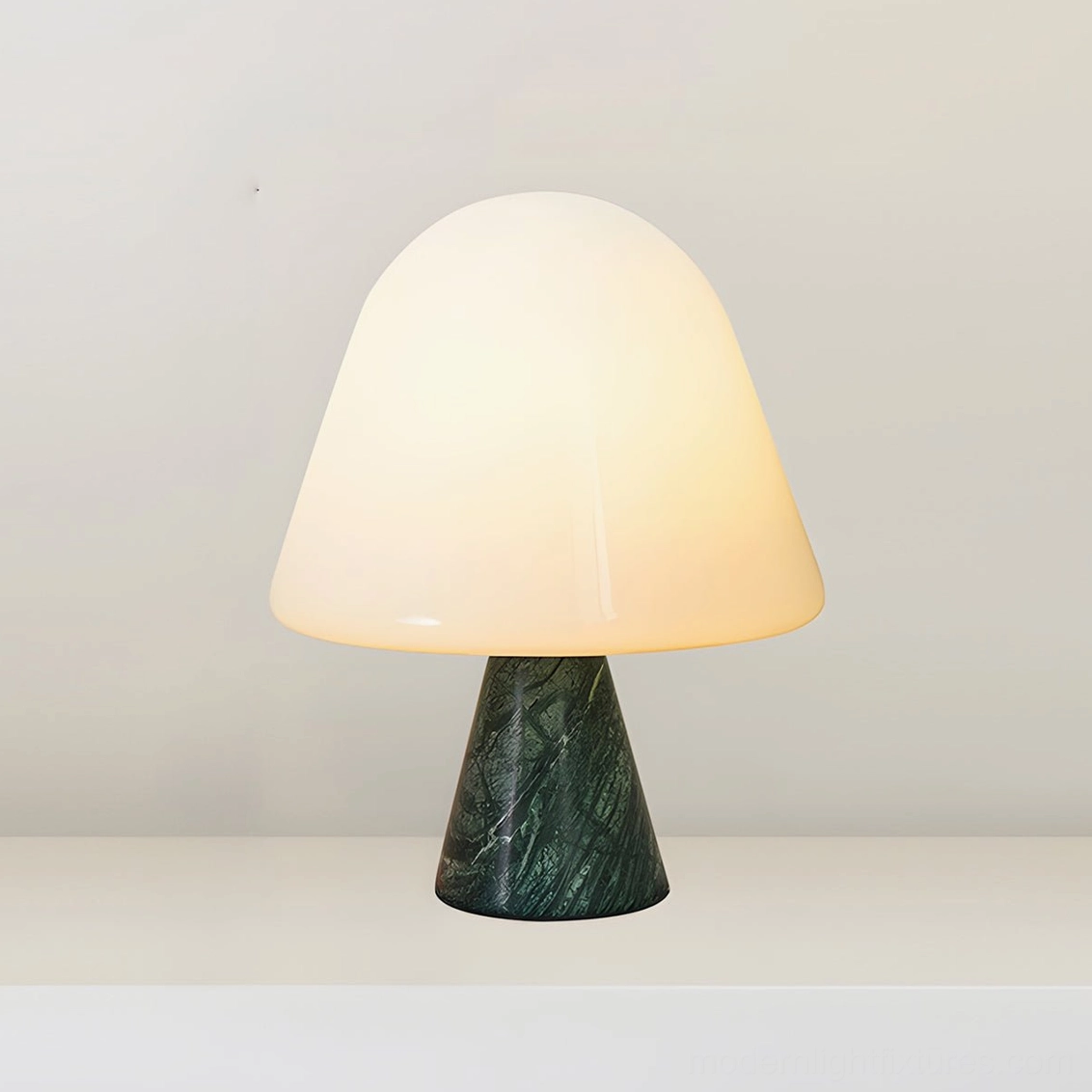 Forest green marble mushroom table lamp creating warm glow in scandinavian minimalist interior with natural decor elements