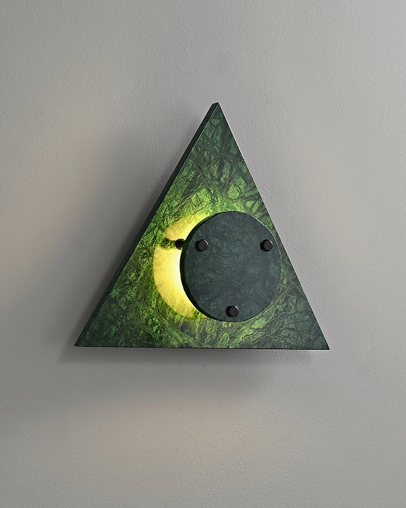 Green translucent marble wall sconce with illuminated central disc and visible mounting hardware