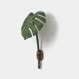 Green monstera leaf wall sconce close-up showing textured botanical design and metal mounting bracket