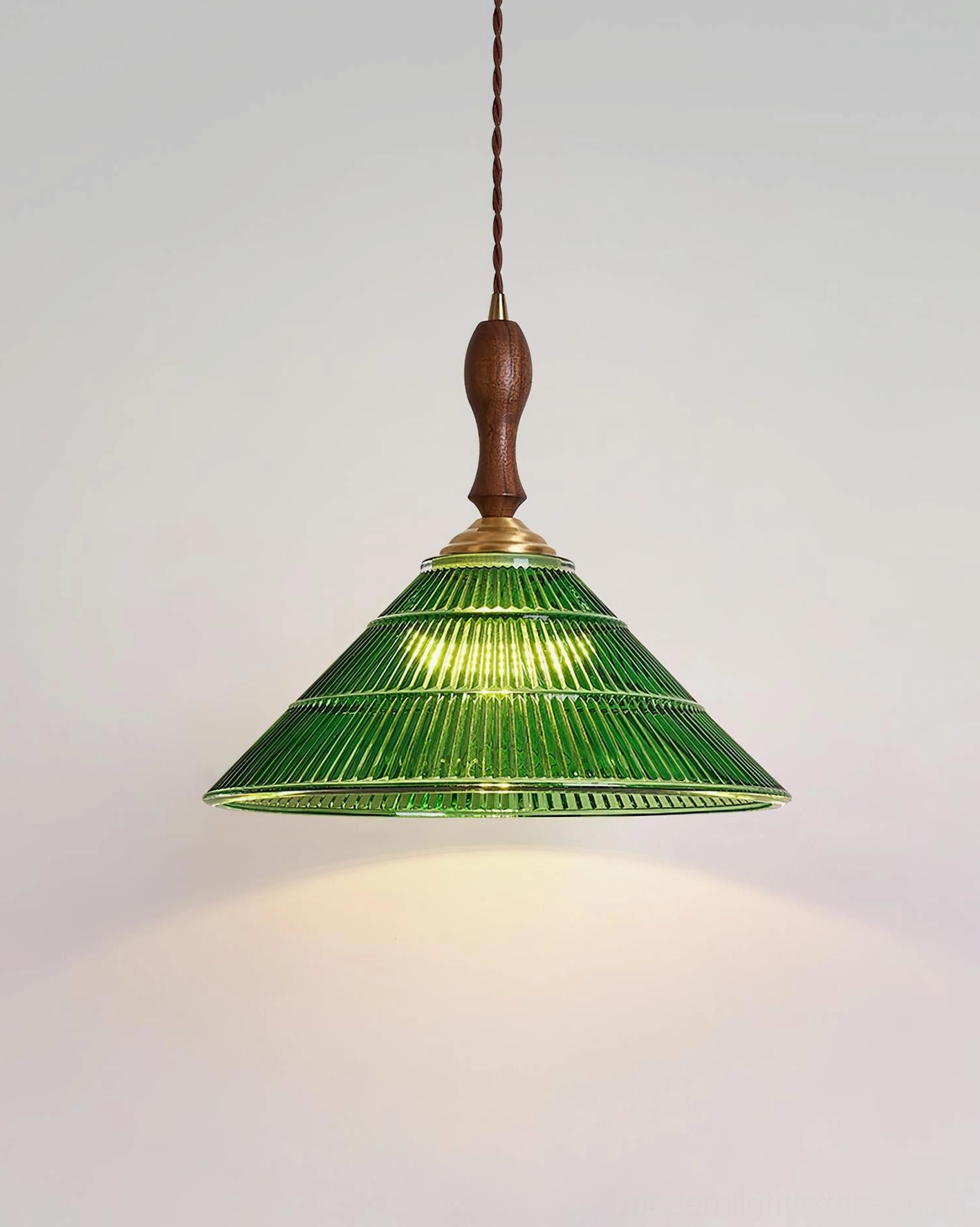 Retro green glass pendant light hanging fixture with warm ambient glow in living space