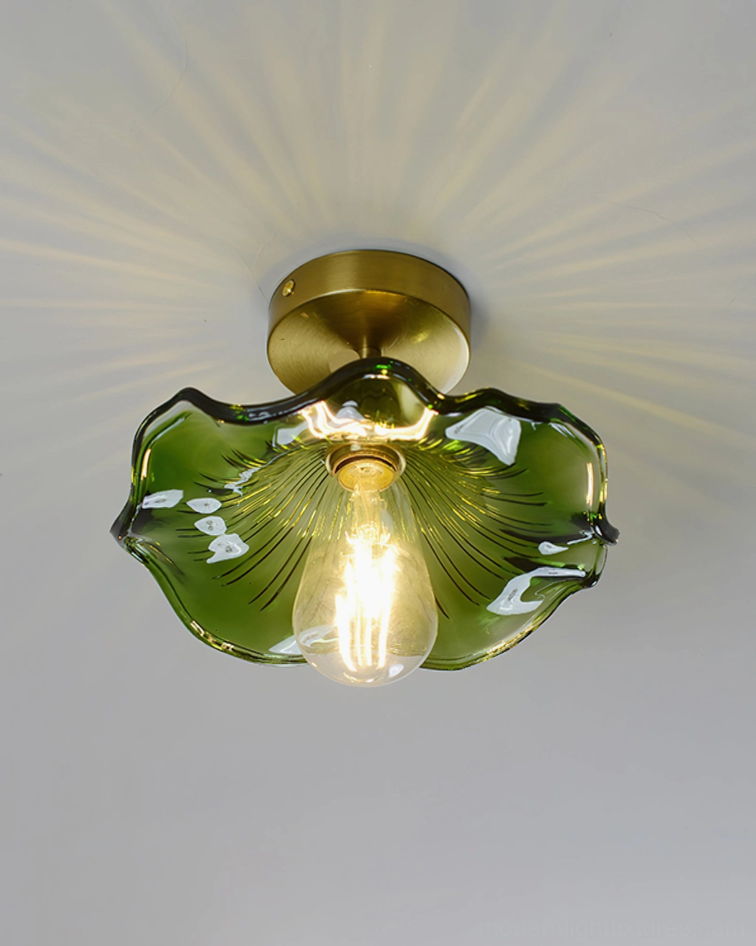 Green petal-edge glass semi-flush light on residential ceiling, warm diffused illumination