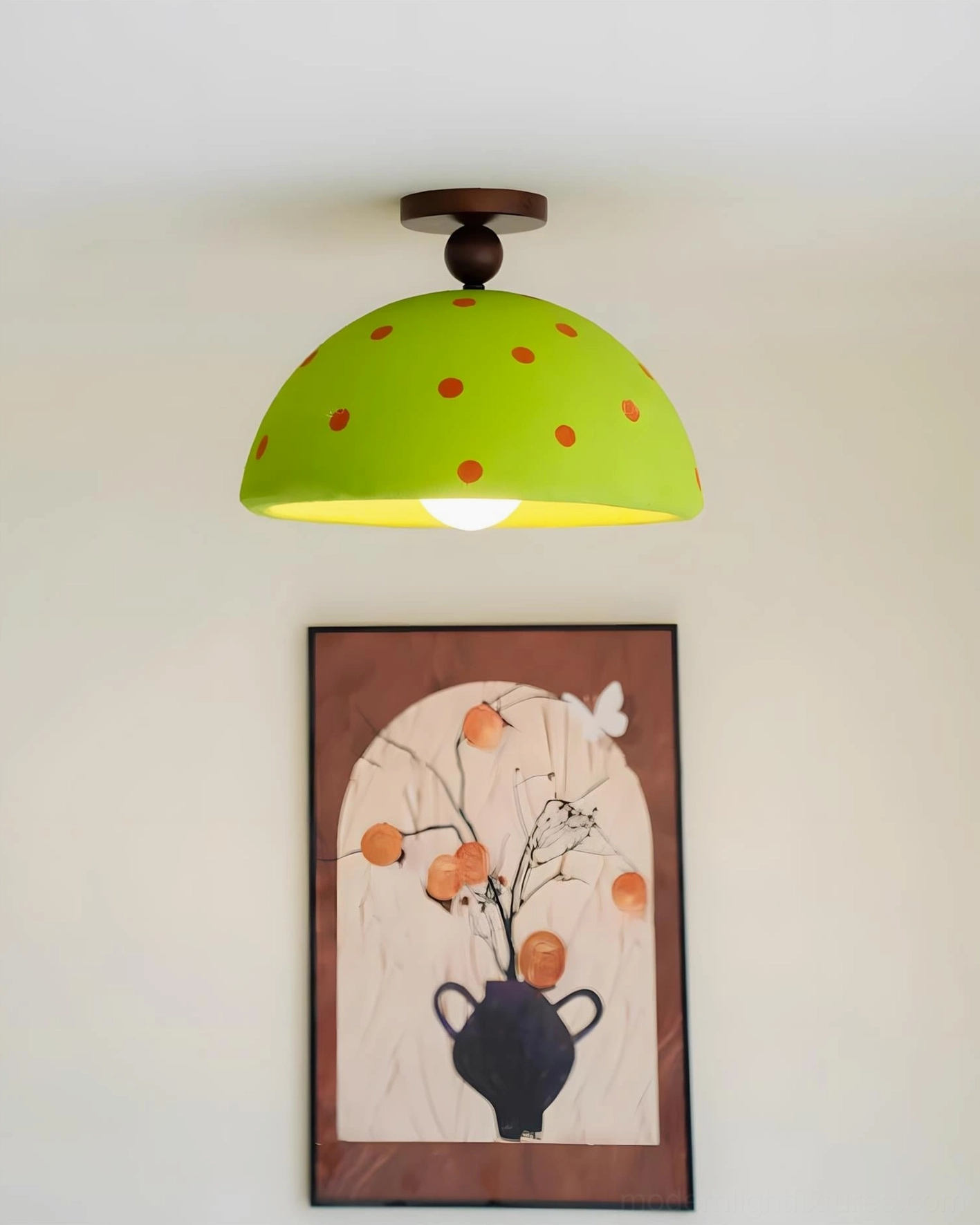 Green polka dot dome ceiling fixture at eye level showing warm light glow and texture