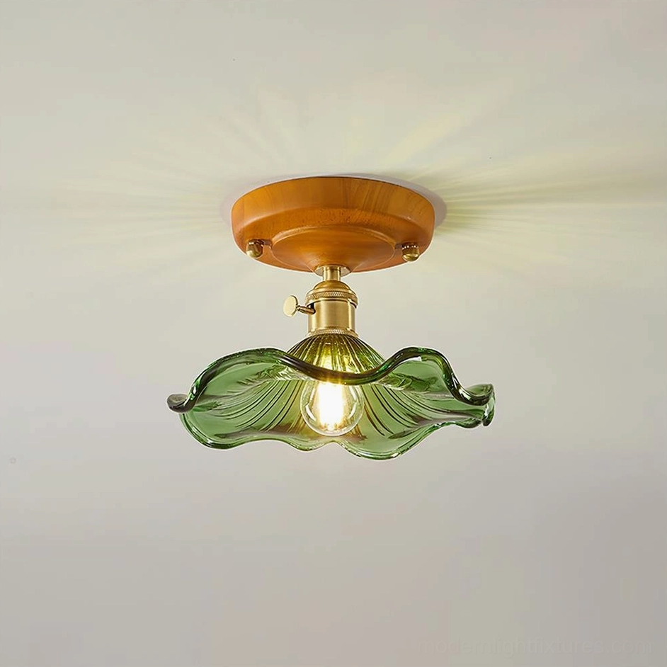 Green ruffled glass flush mount ceiling light with brass switch and wood base, studio view