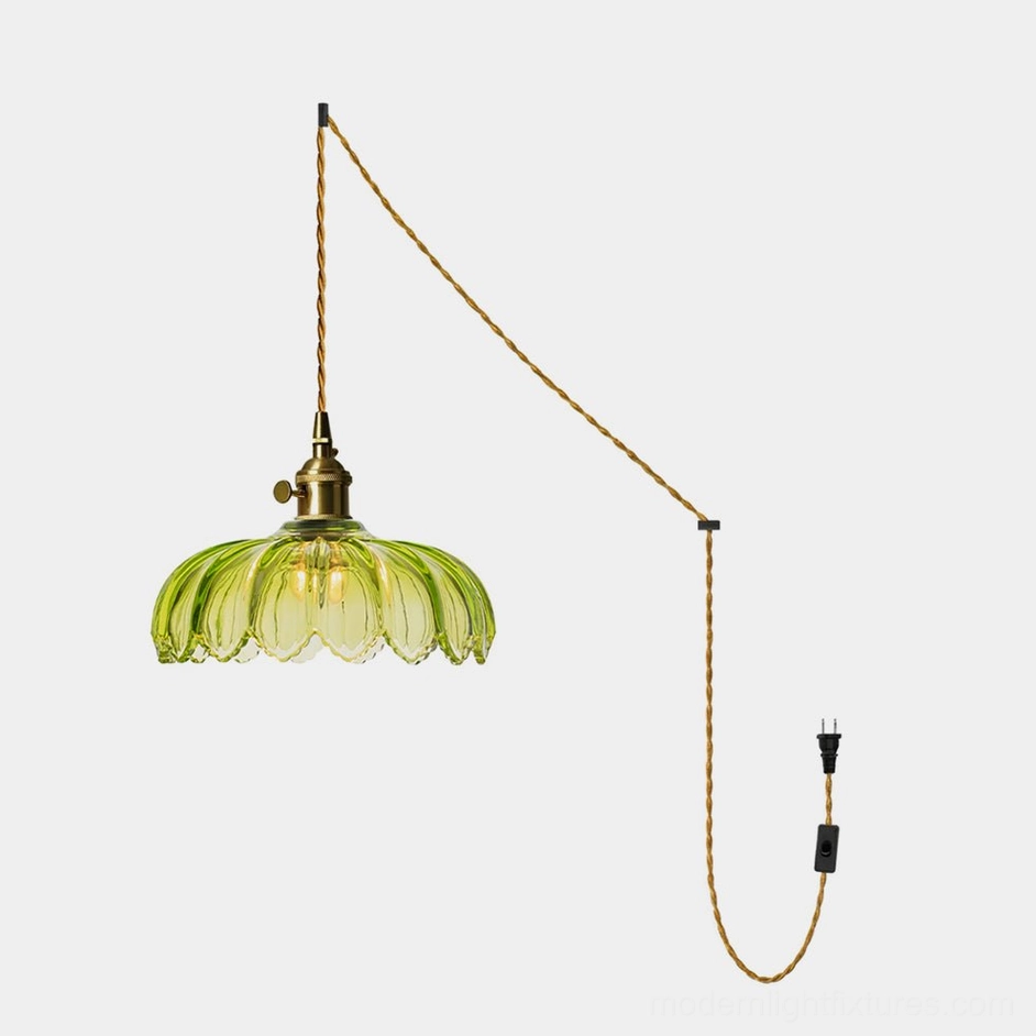Green fluted glass plug-in pendant light with scalloped petal shade and brass fixture on white background