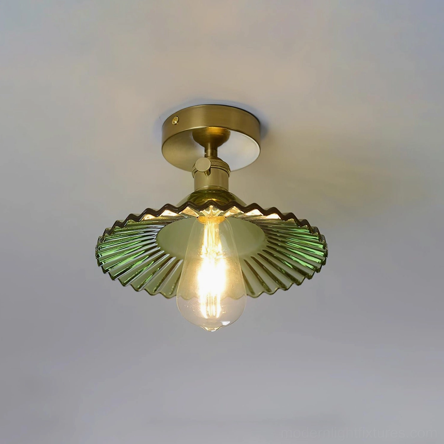 Green semi-flush ceiling light with wavy glass shade, brass base in transitional home interior