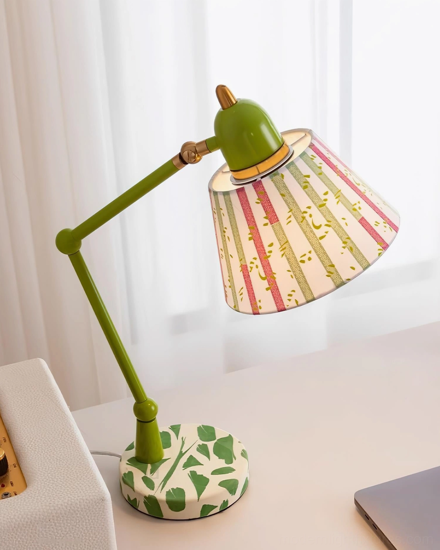 Articulated green desk lamp with ornamental leaf base detail and artistic fabric shade, side angle view