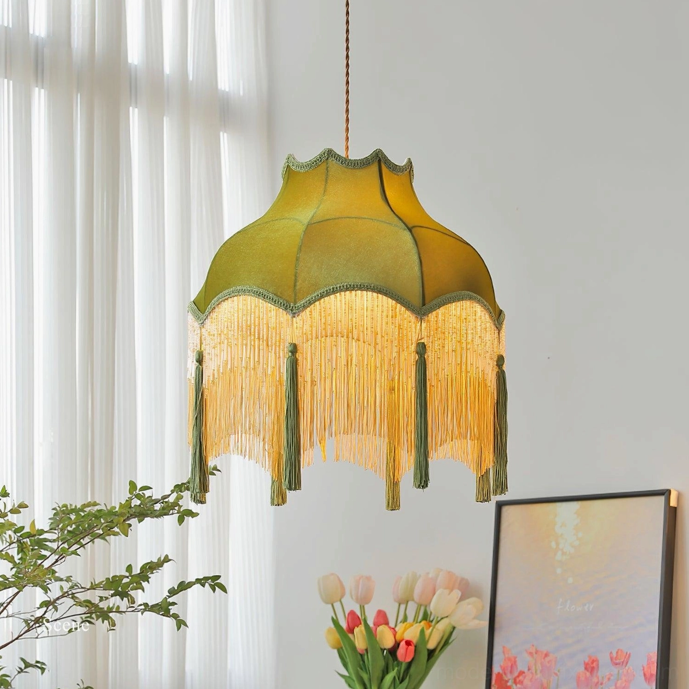 Green velvet tassel chandelier displayed in bright living room with plants and artwork