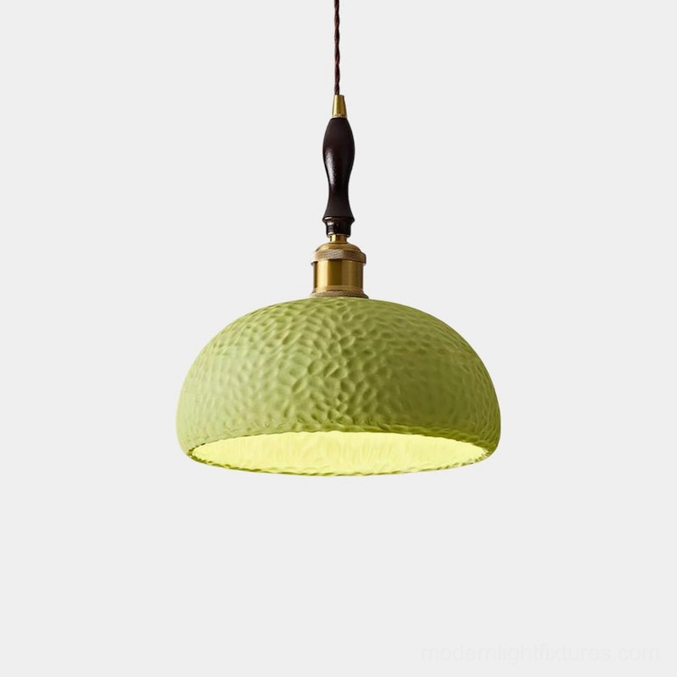 Textured green resin dome pendant light with brass and wood hardware, front view against white background