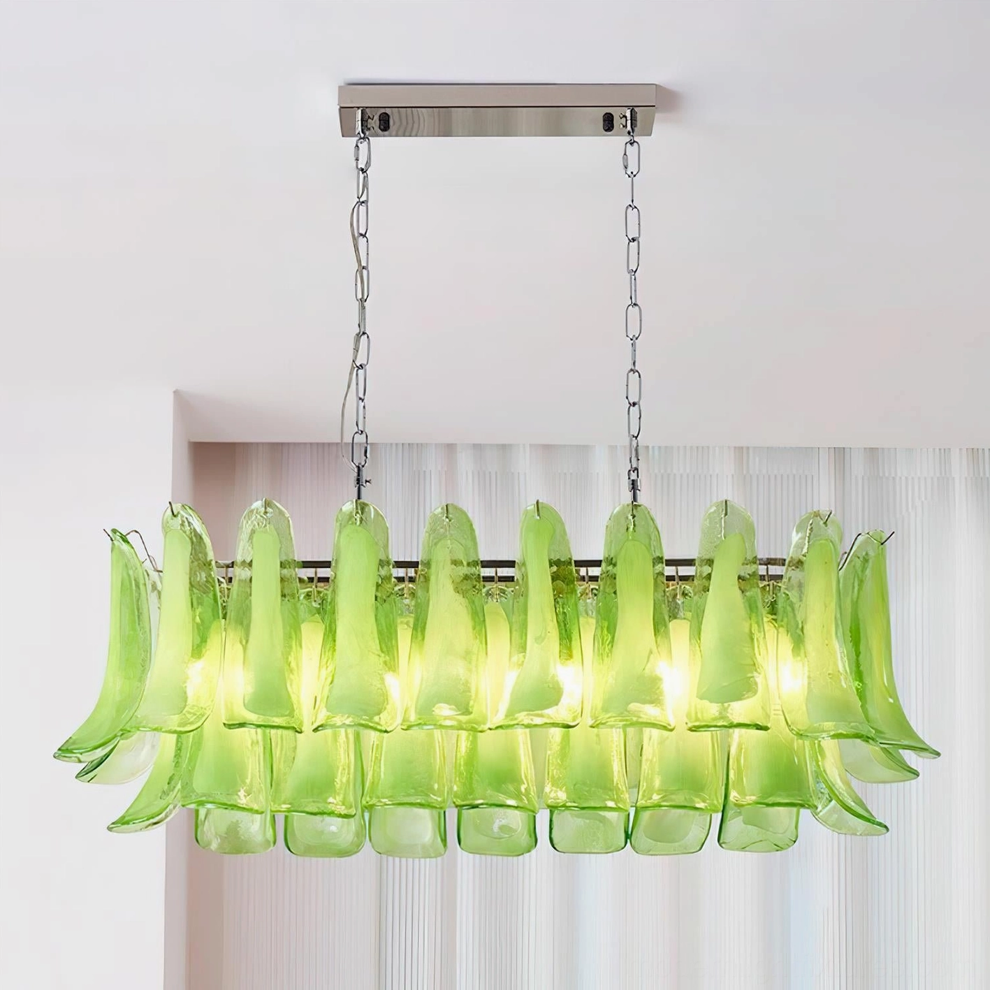 Illuminated green tulip leaf chandelier casting warm light through glass pendants in contemporary interior