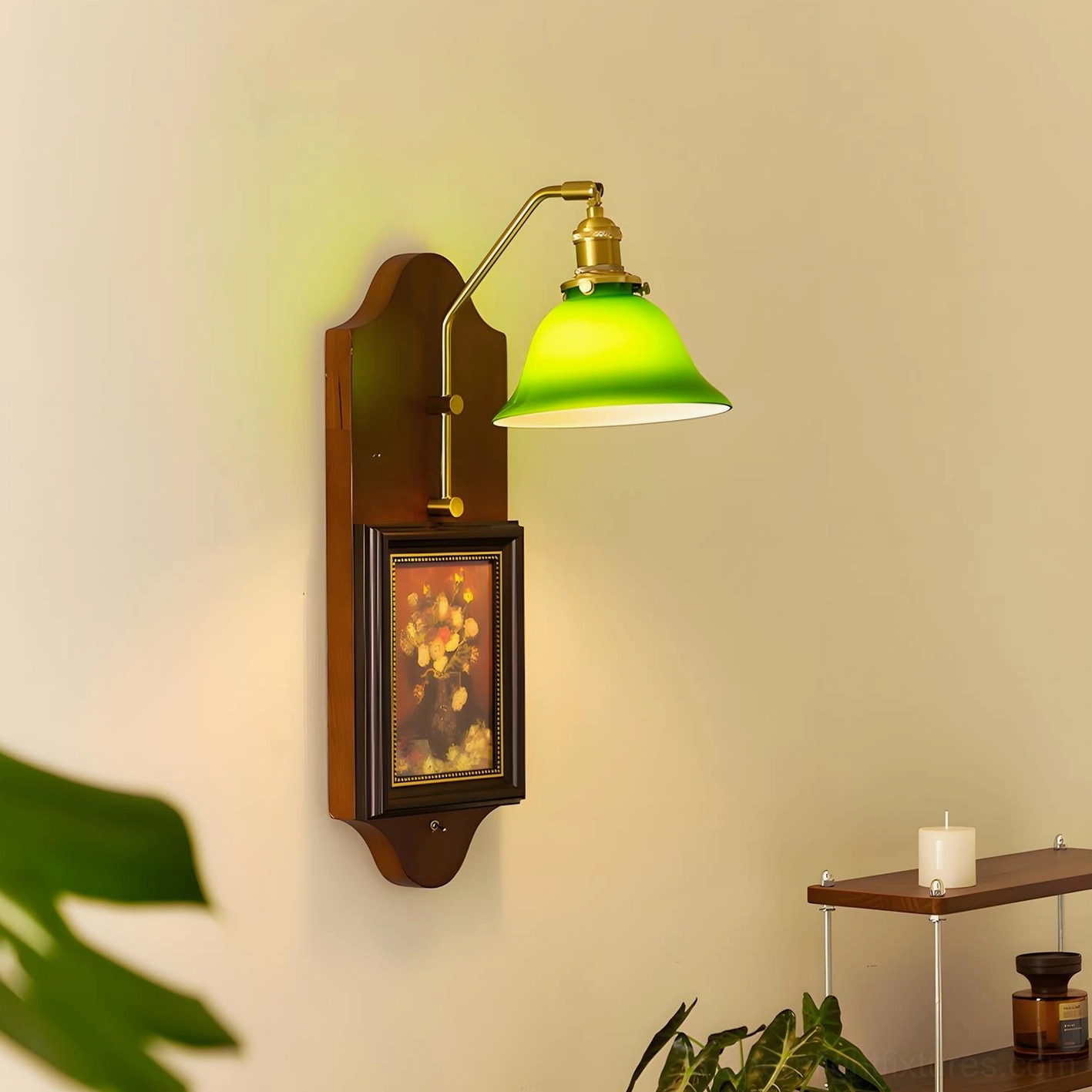 Left-side profile of vintage wall sconce with lit emerald shade and framed floral artwork display