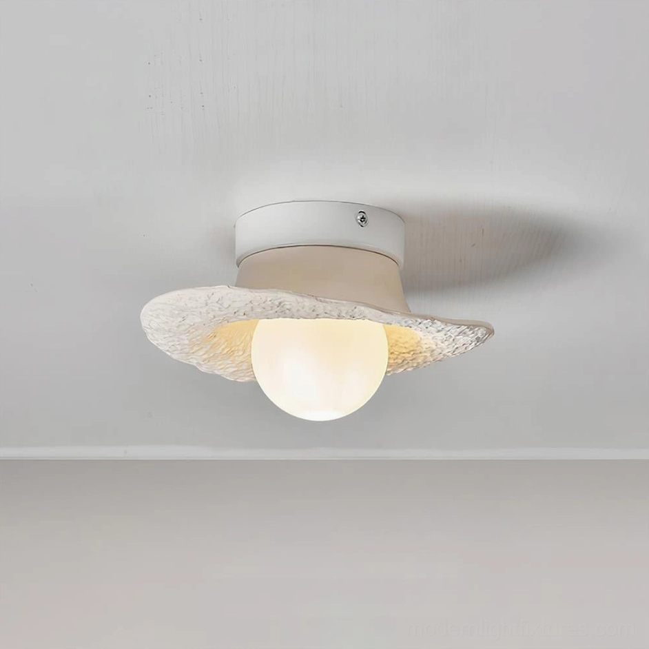 Grima matte off-white hat ceiling light front close-up with warm glowing central bulb and textured surface