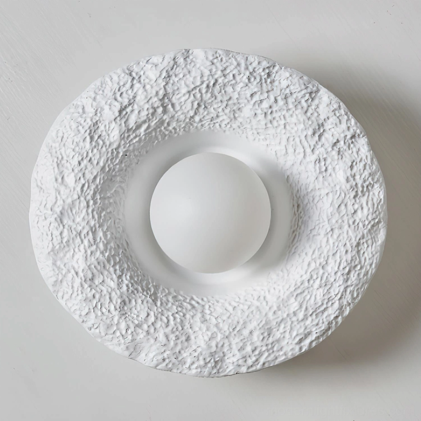 Grima white matte textured hat ceiling light top-down flat lay view showing uneven brim surface and central bulb