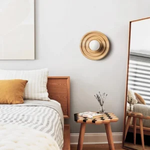 Grove ash wood wall sconce installed in minimalist bedroom beside bed as warm ambient bedside lighting fixture