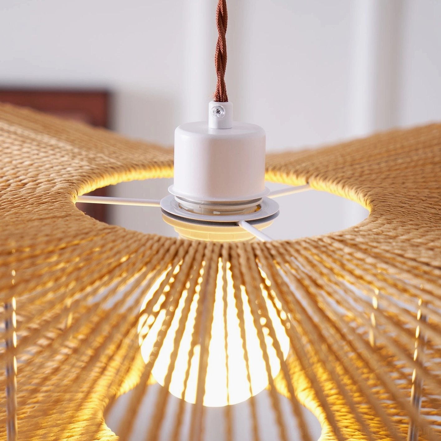 Gunilla woven hemp rope pendant light creating ambient shadow play and dramatic lighting effect on ceiling
