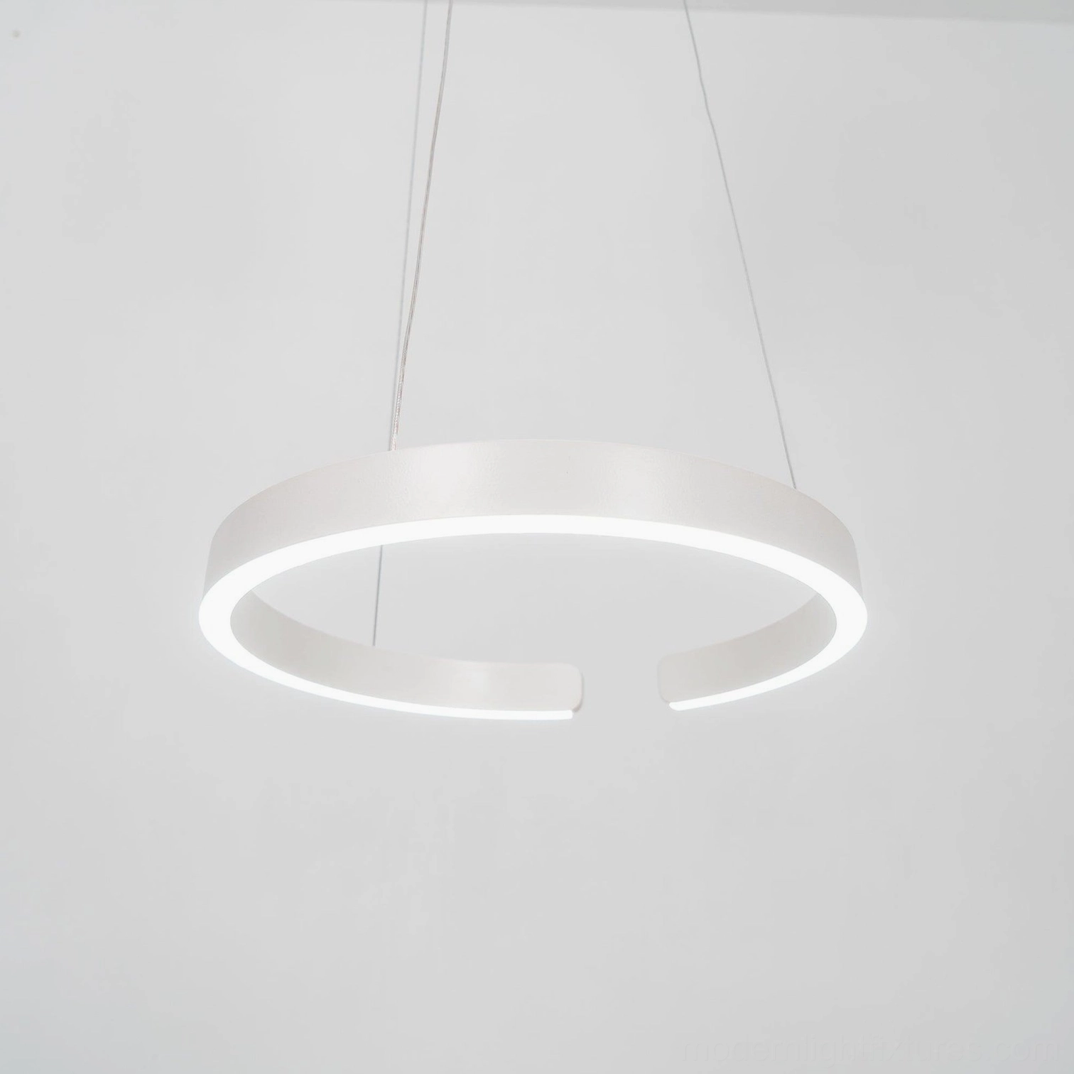 Halo pendant light establishing focal points above contemporary seating arrangements in living rooms