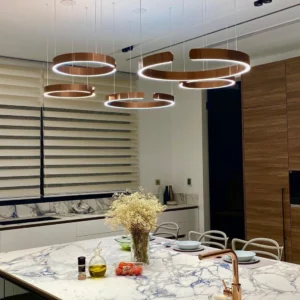 Multiple rose gold halo ring pendant lights installed in contemporary kitchen dining area with ambient warm lighting