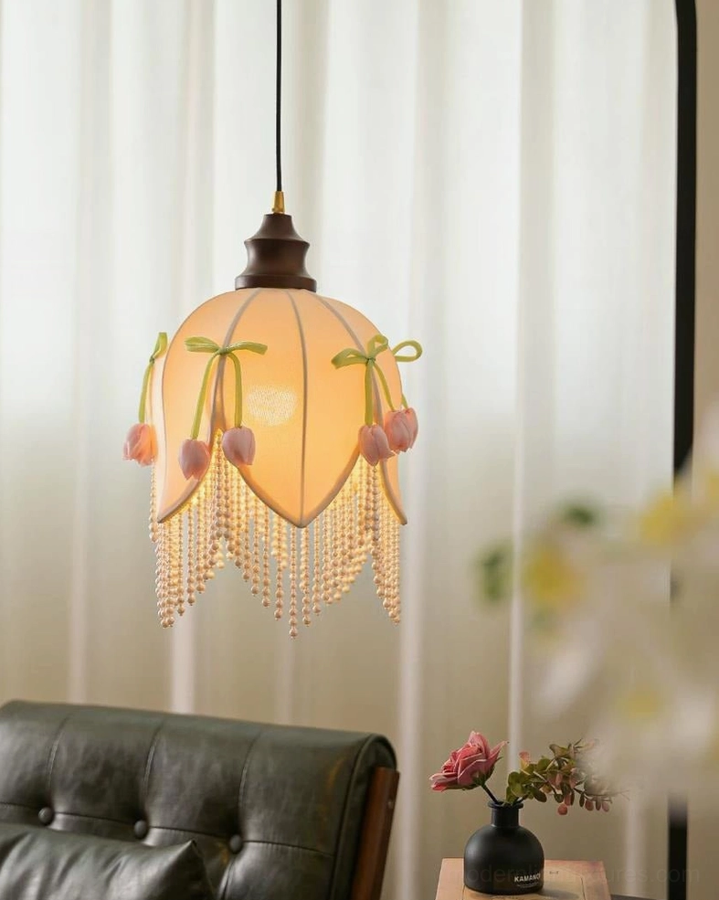Hanavelle cream tulip pendant light product detail showing ash wood stem, brass-tone cap, petal-seamed fabric construction, and decorative green velvet bows with pink tulip buds