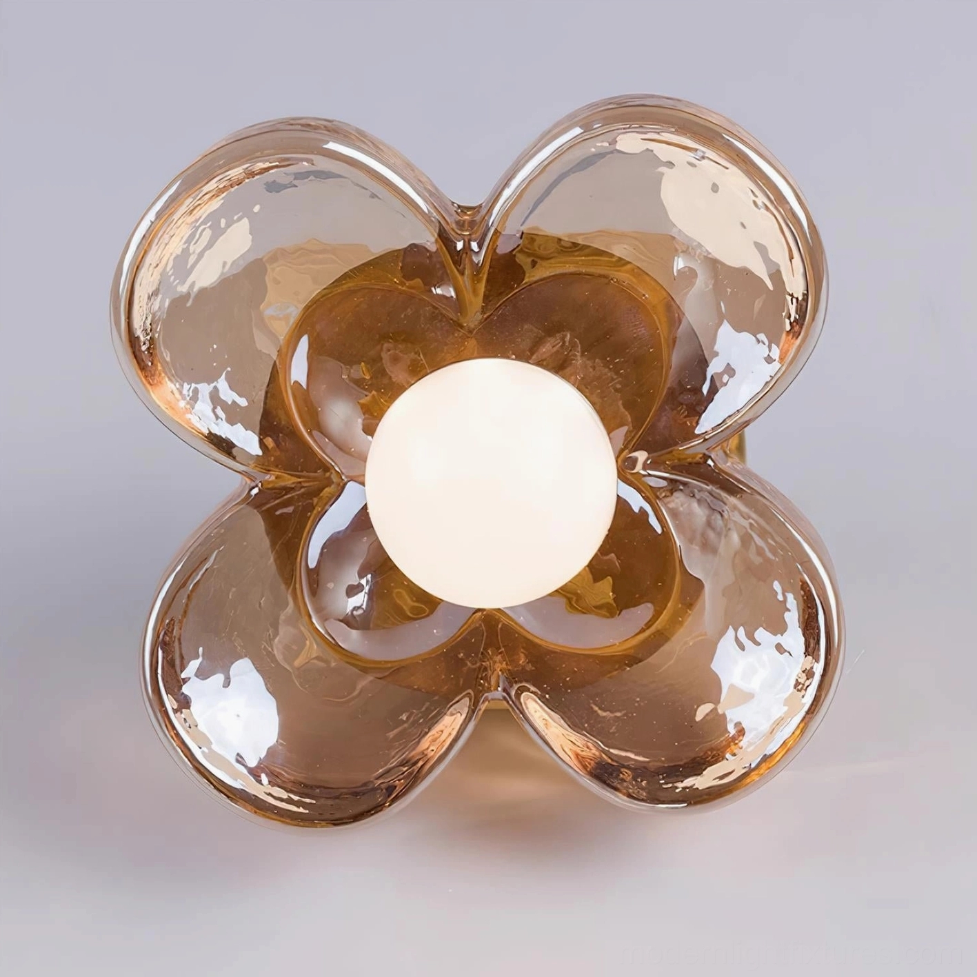 Close-up front view of hand-blown amber bubble glass four-leaf clover light fixture with central white LED bulb