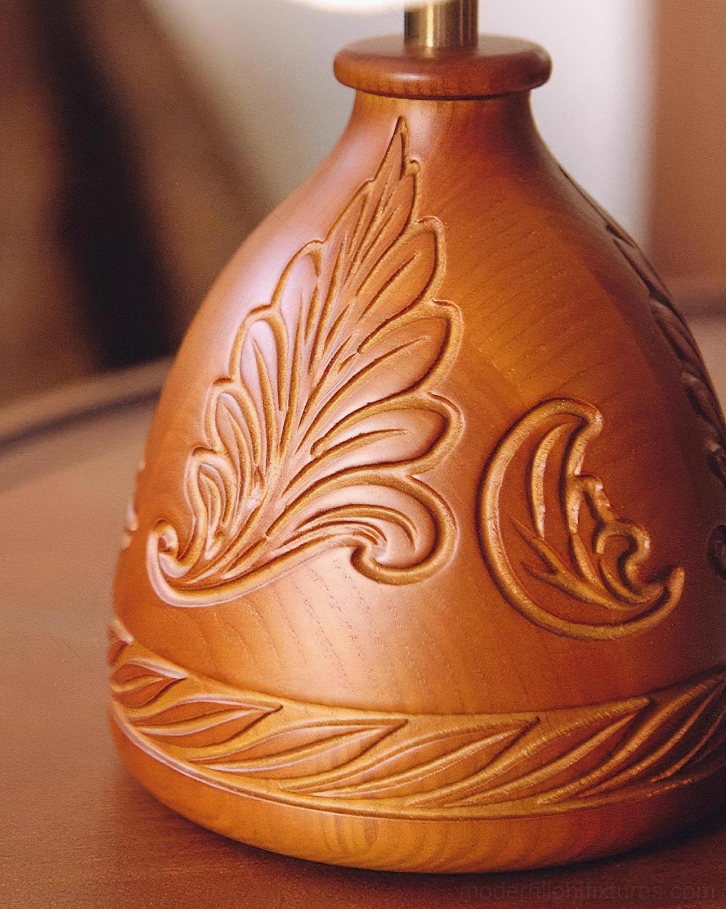 Close-up macro photography of carved wooden base showing intricate leaf and scroll pattern details