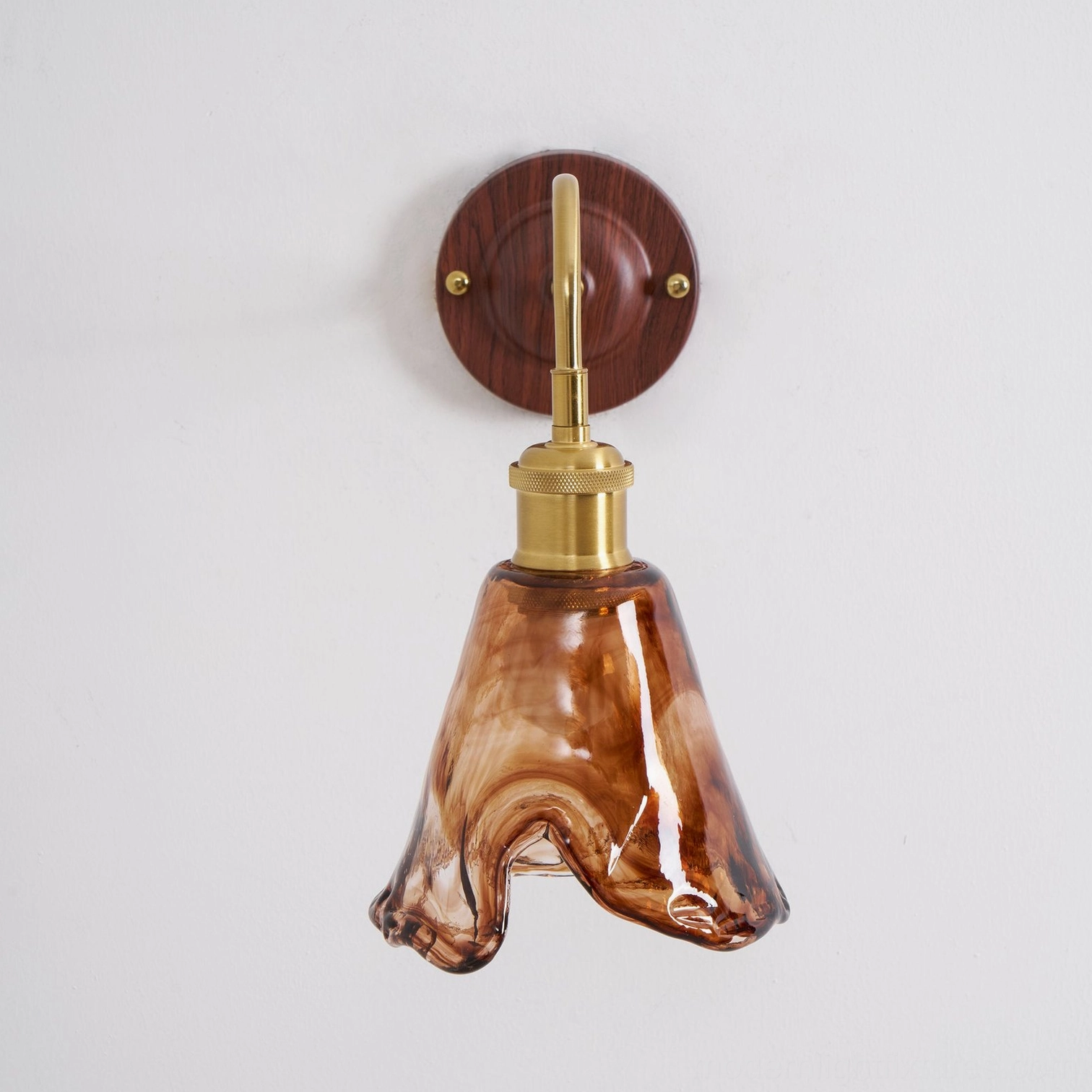 Modern amber glass wall lamp close-up highlighting hand-crafted ripple patterns and glass quality
