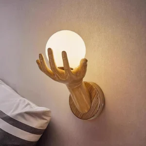 Hand of Victory wall sconce mounted on bedroom bedside wall with warm ambient lighting and wooden hand detail