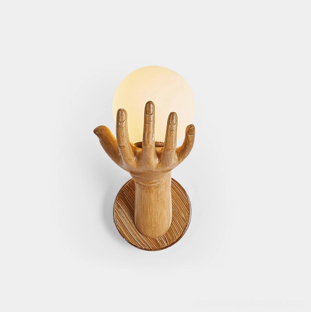 Hand of Victory sculptural wall sconce with wood grain finish and frosted glass globe - front studio view