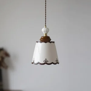 Close-up of ceramic pendant lamp shade showing intricate hand-painted details and scalloped edge trim on white porcelain