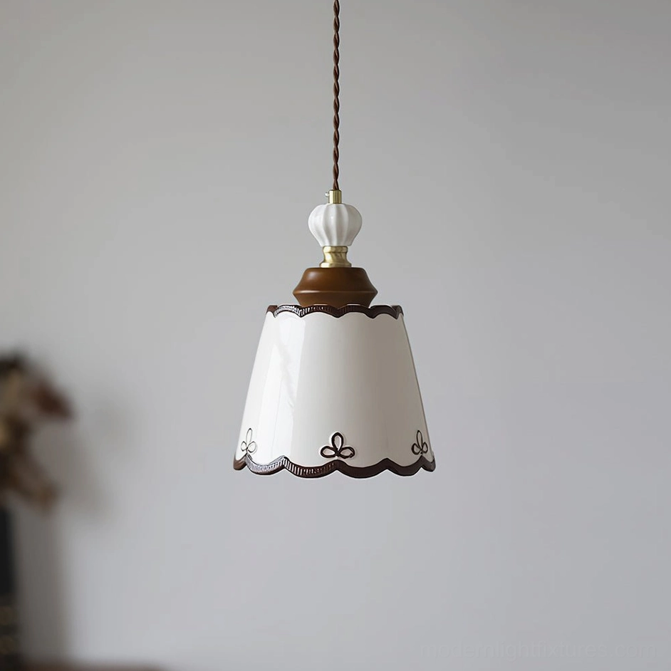 Close-up of ceramic pendant lamp shade showing intricate hand-painted details and scalloped edge trim on white porcelain